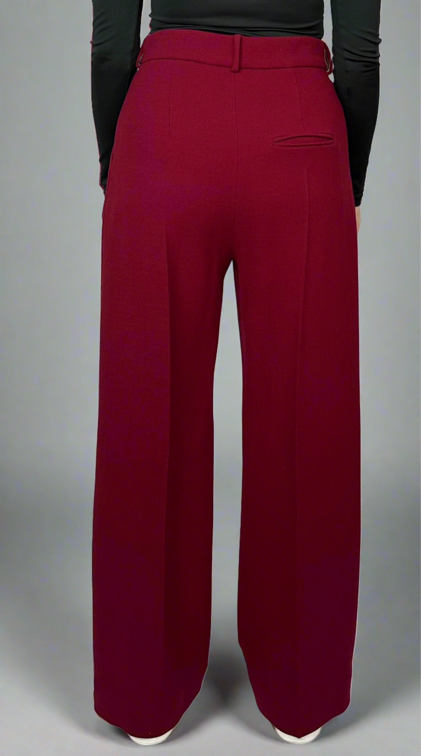 Back view of model showcasing Sartorial Flair burgundy wide-leg trousers with tailored fit, paired with a black top, emphasizing the elegant design and quality fabric.