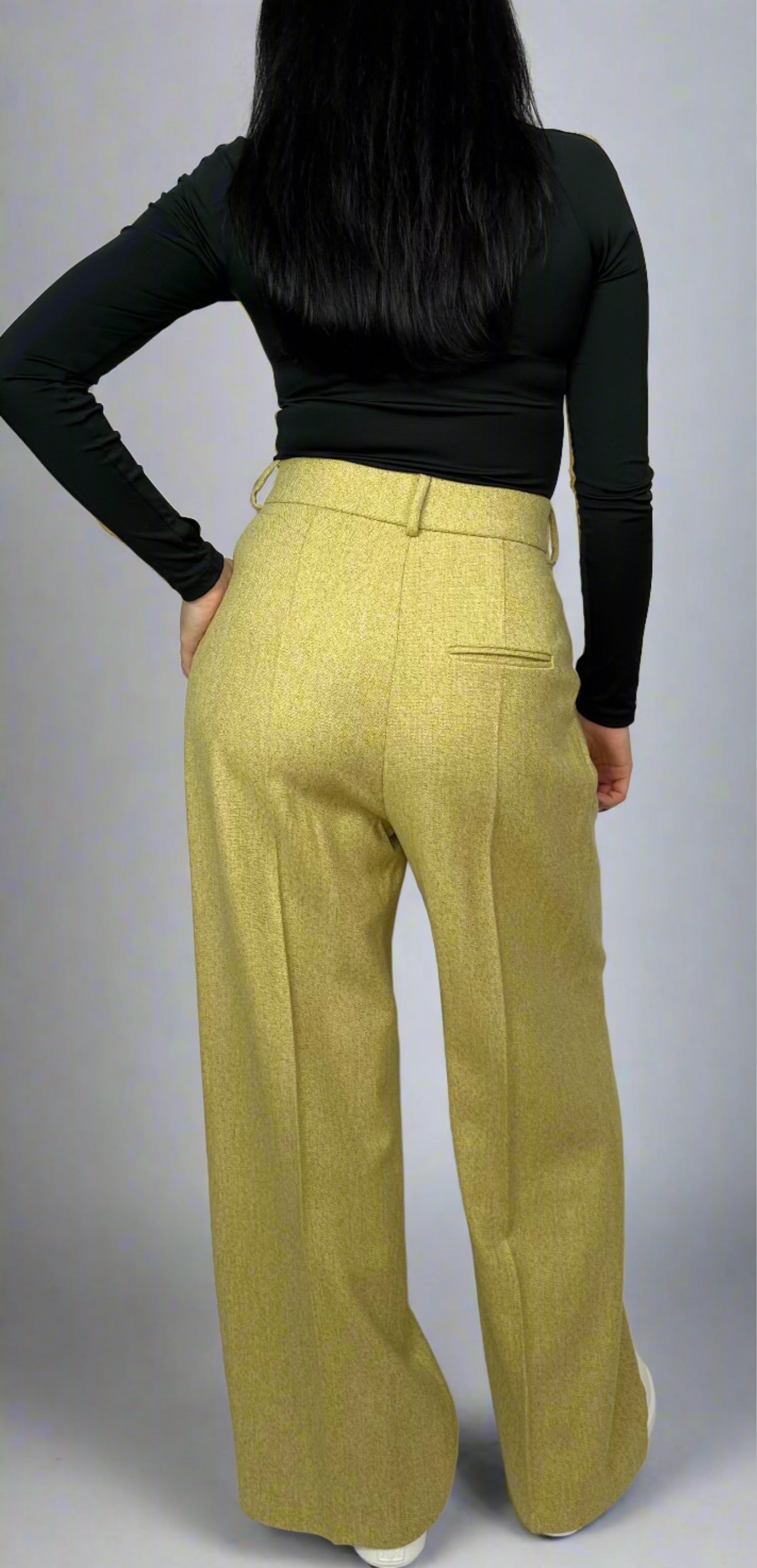 Rear view of a woman in Sartorial Flair chartreuse wide-leg trousers, highlighting the expert tailoring with a fitted waistband and elegant drape, perfect for a sophisticated style.