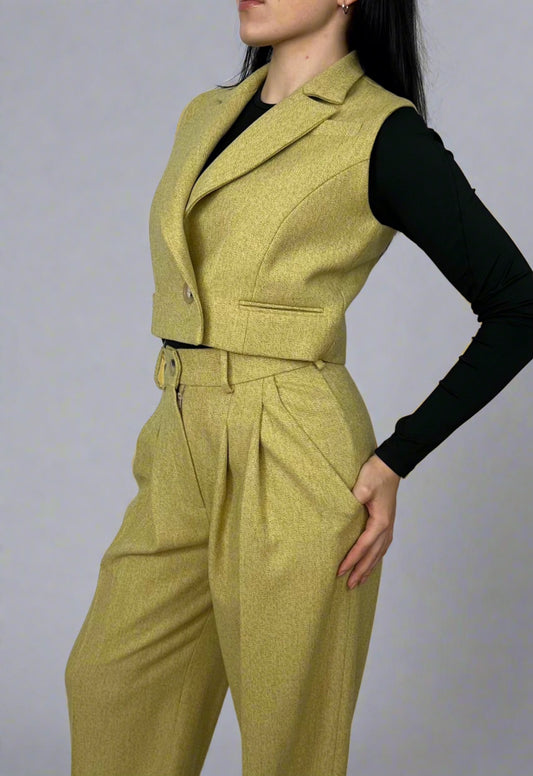 Elegant side pose of a woman in Sartorial Flair’s chartreuse waistcoat and matching wide-leg trousers, highlighting the waistcoat’s sharp lapel detail and tailored fit, paired with a black top. This outfit exemplifies chic, sustainable fashion, perfect for empowering the modern woman.