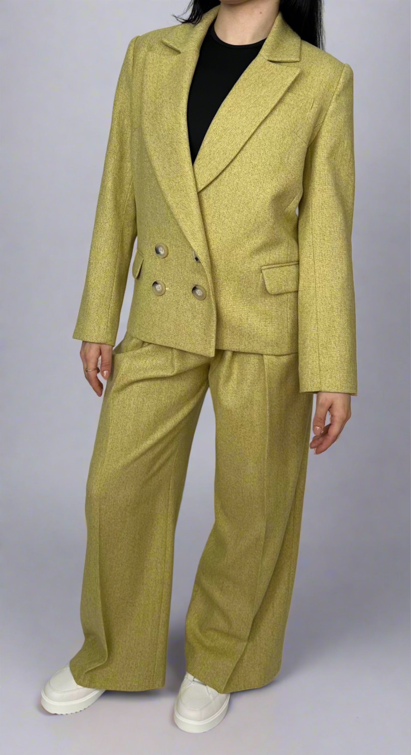 Elegant woman wearing a chartreuse double-breasted Sartorial Flair suit, showcasing a sharp lapel blazer paired with tailored trousers for a sophisticated and modern look.