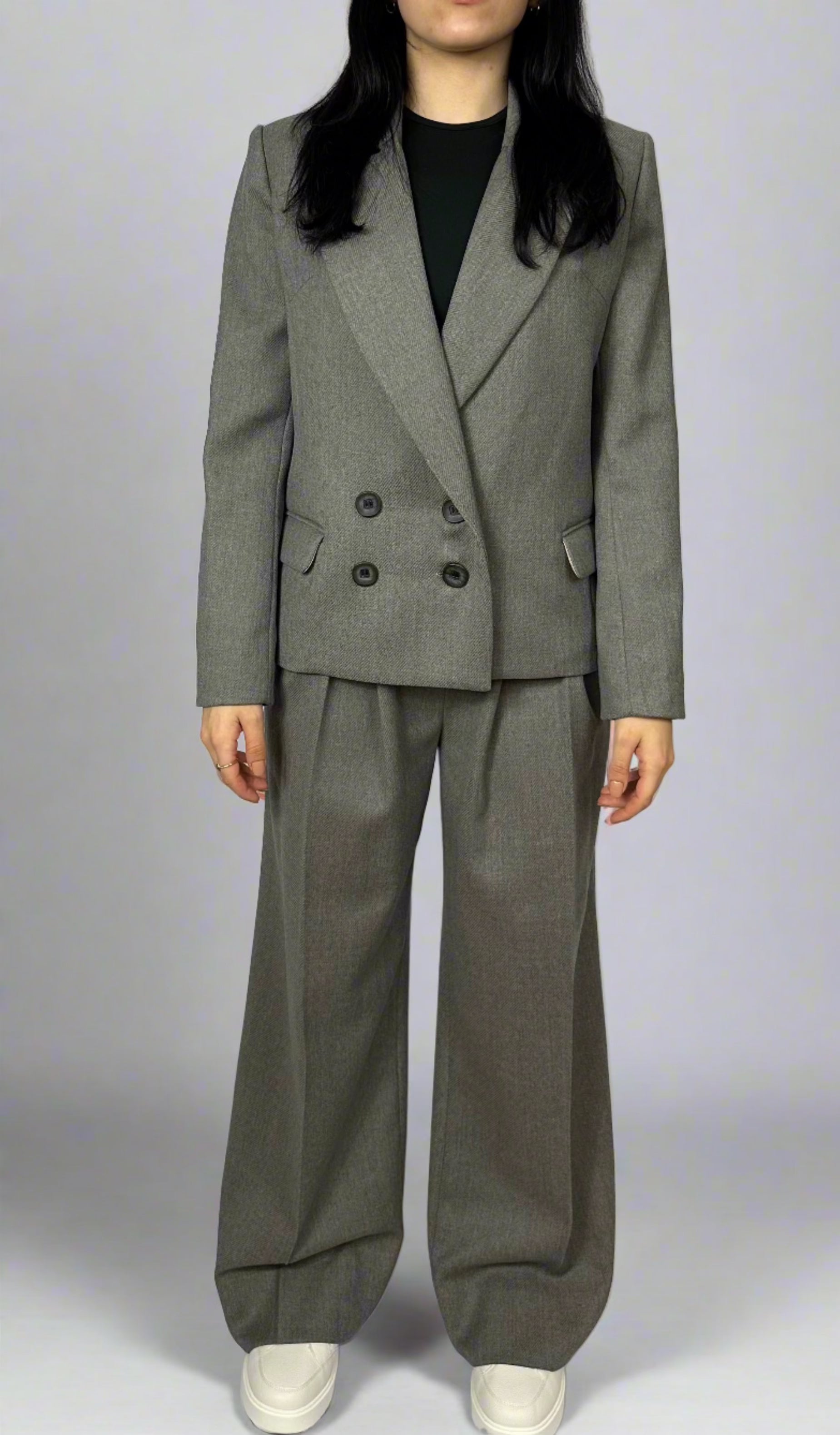 Elegant woman wearing Zoe gray tailored suit with double-breasted blazer and matching wide-leg trousers, showcasing classic and professional style from Sartorial Flair.