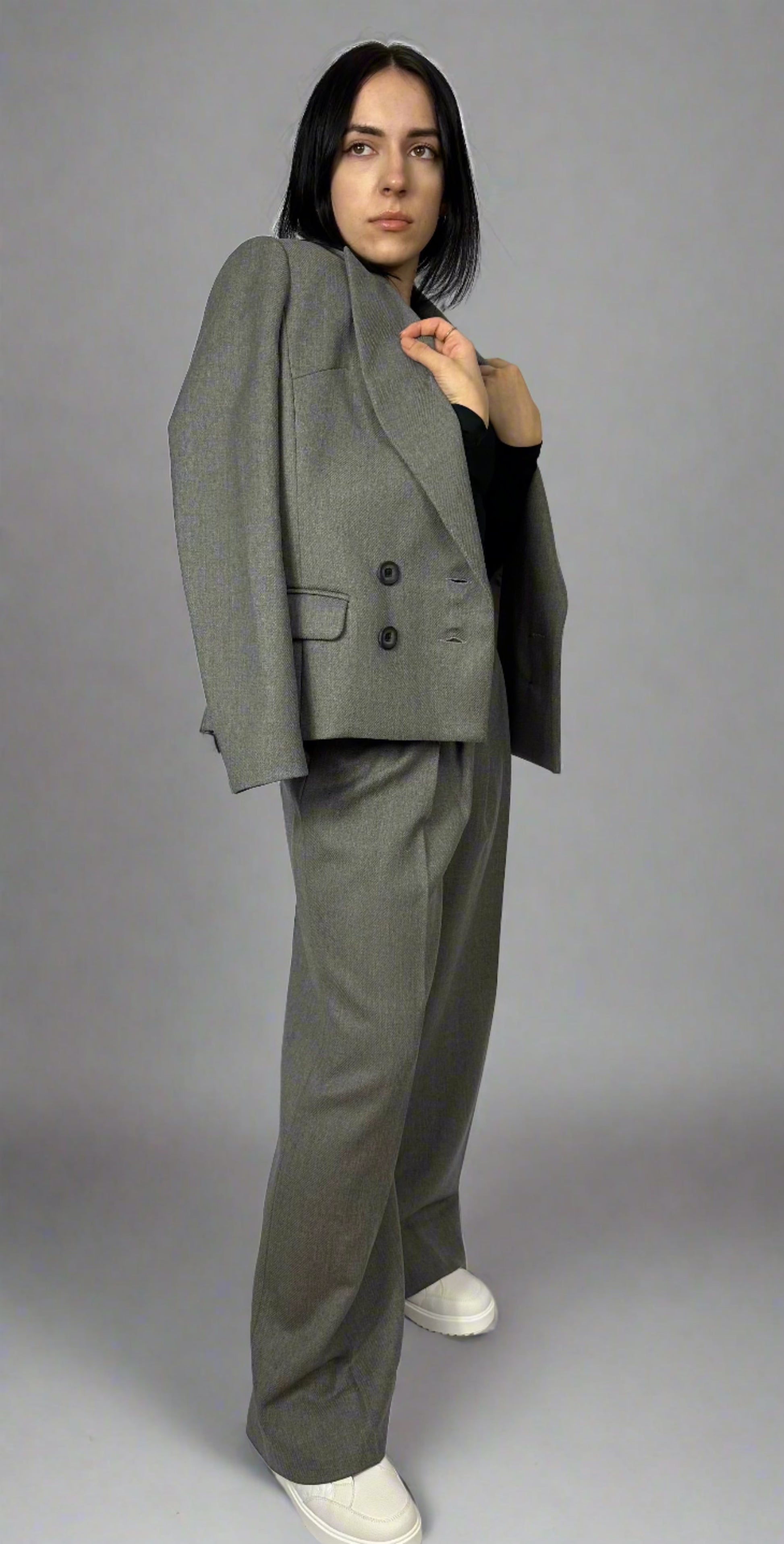 Sleek and modern woman in a gray Zoe suit with double-breasted blazer and wide-legged trousers, demonstrating a stylish, professional attire, available exclusively at Sartorial Flair.